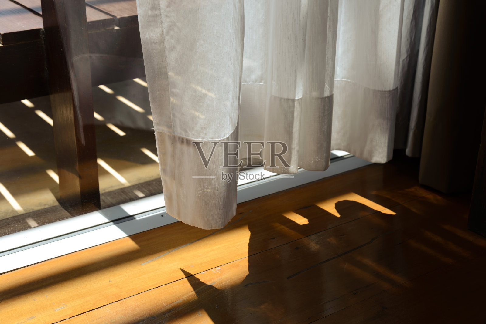 白色的透明窗帘，明亮的阳光和木地板。窗帘布照片摄影图片