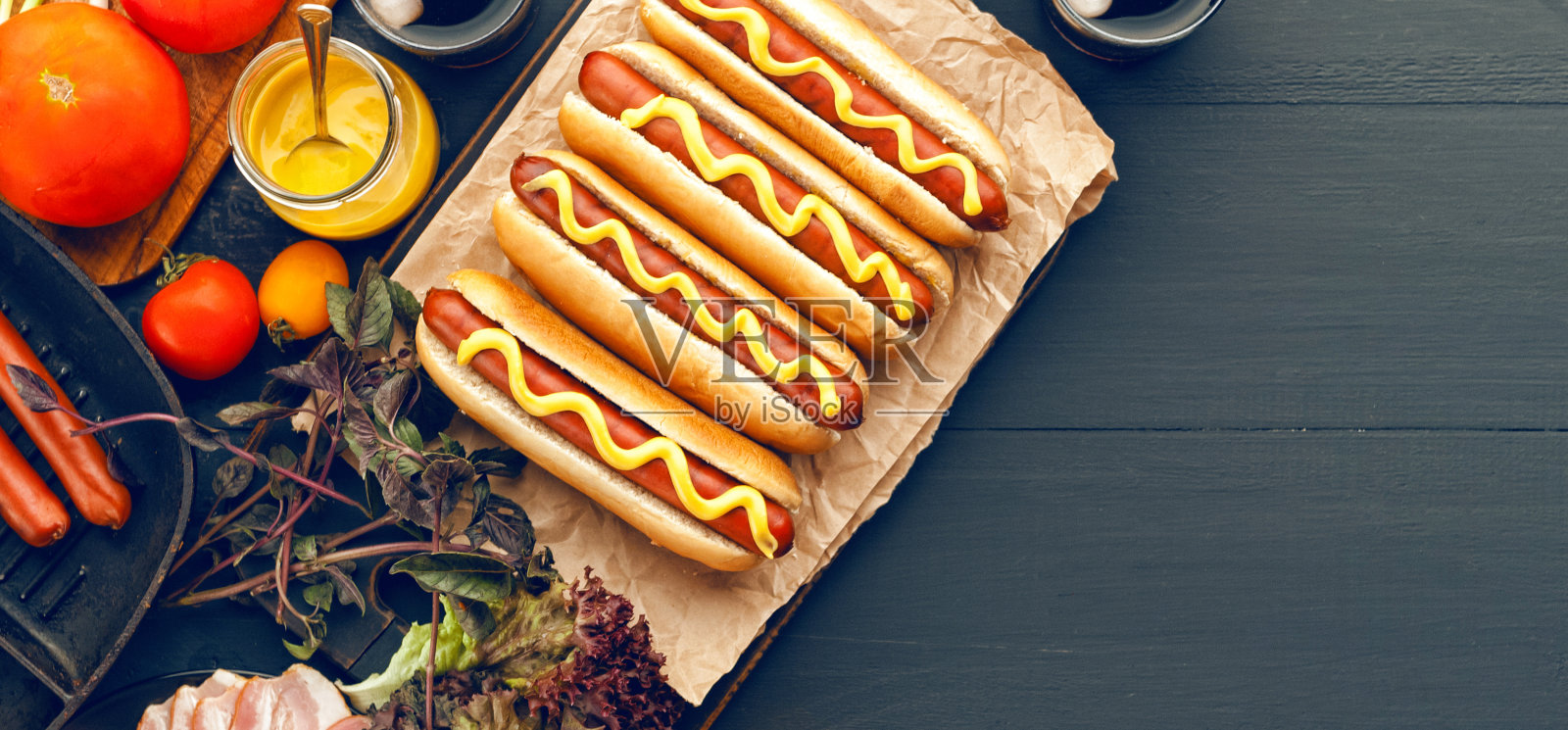 烤热狗与黄色的美国芥末，在黑暗的木制背景照片摄影图片