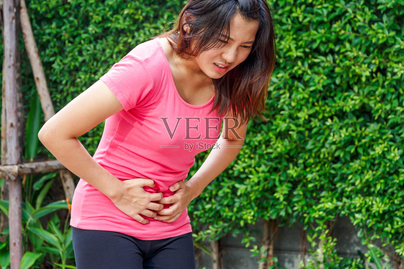 亚洲女性触碰自己的腹部与腹痛或月经，疼痛的概念。照片摄影图片