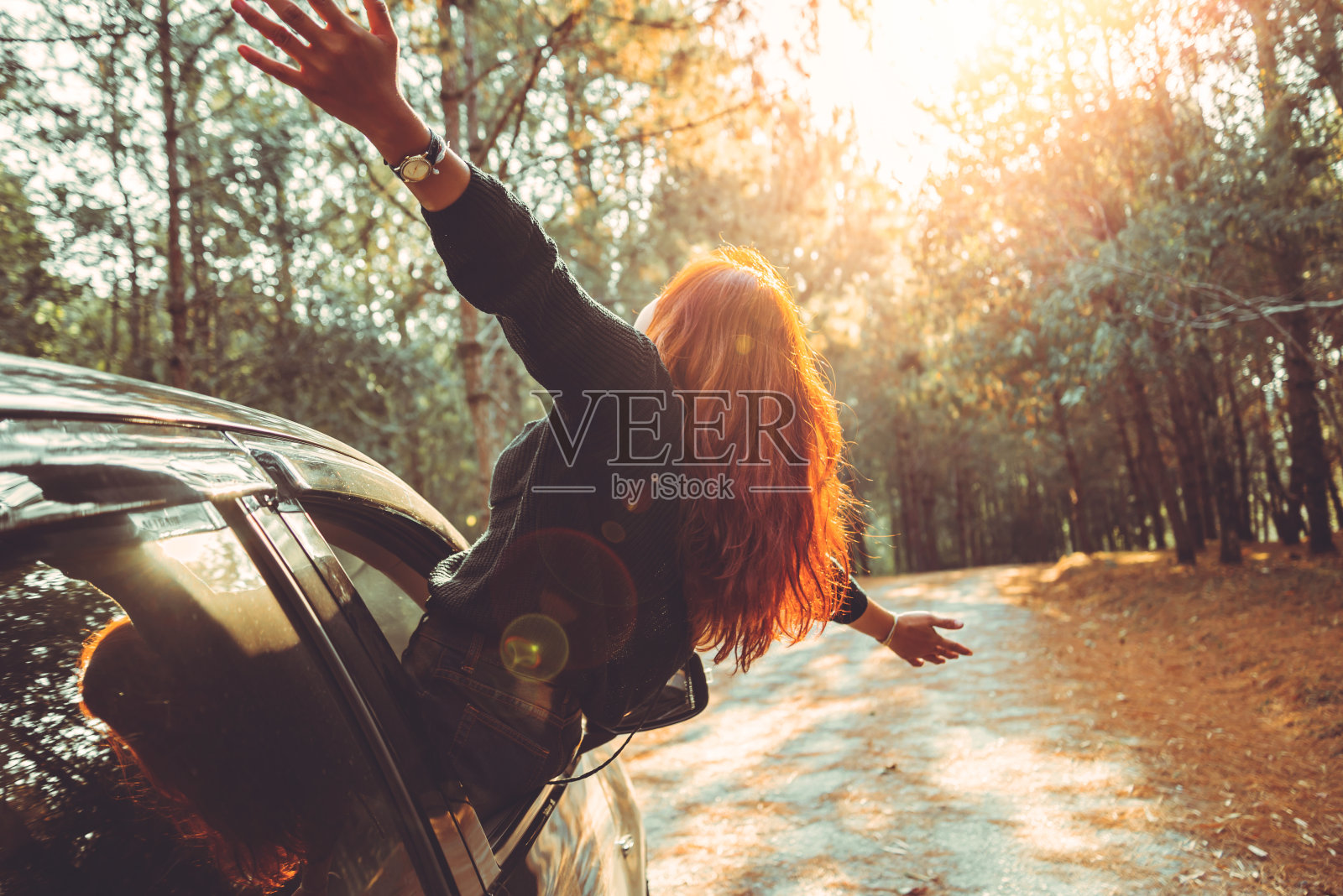 女人开着车快乐地旅行。照片摄影图片