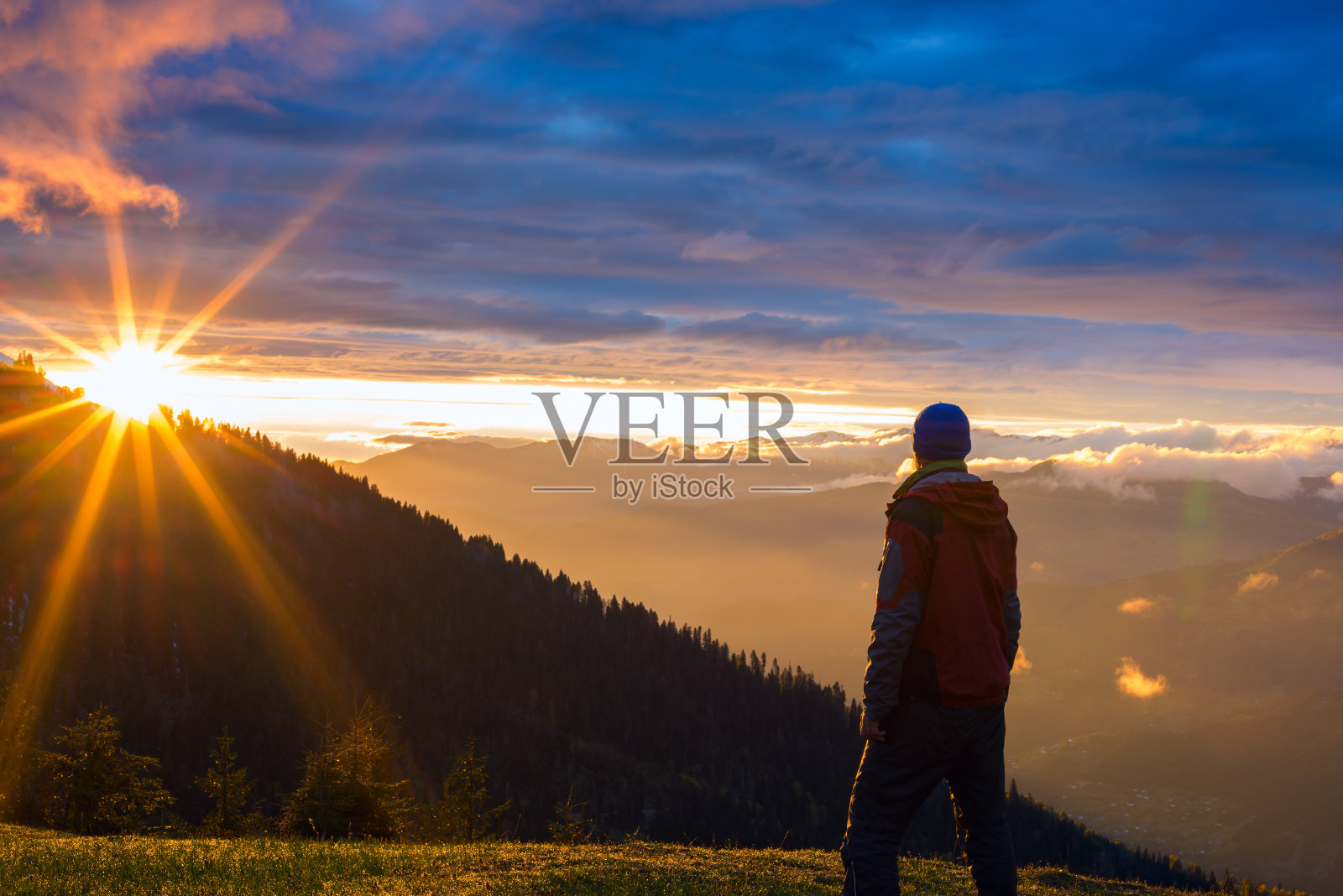 孤独的旅人站在山上，夕阳西下照片摄影图片