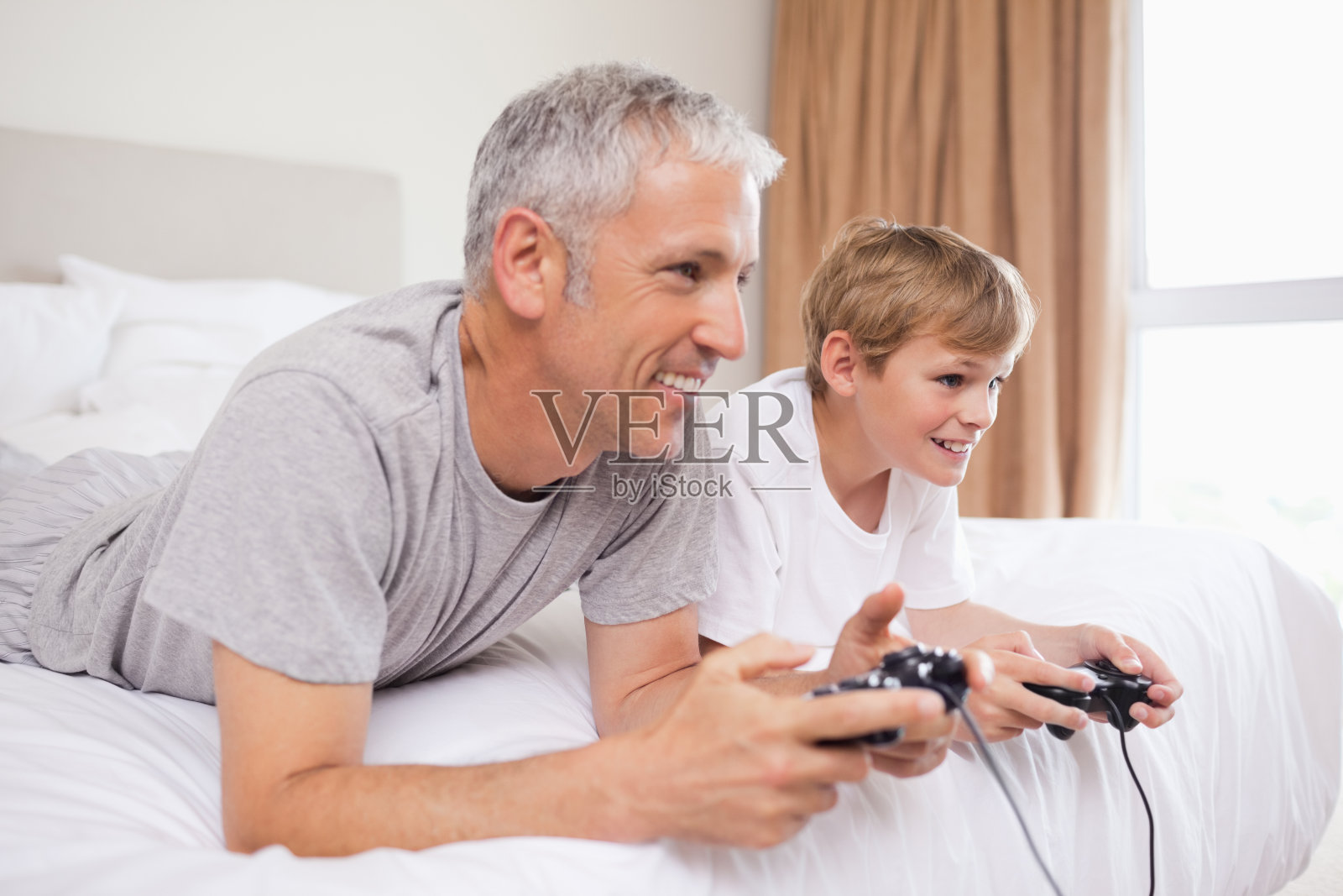 快乐的父亲和他的儿子玩电子游戏照片摄影图片
