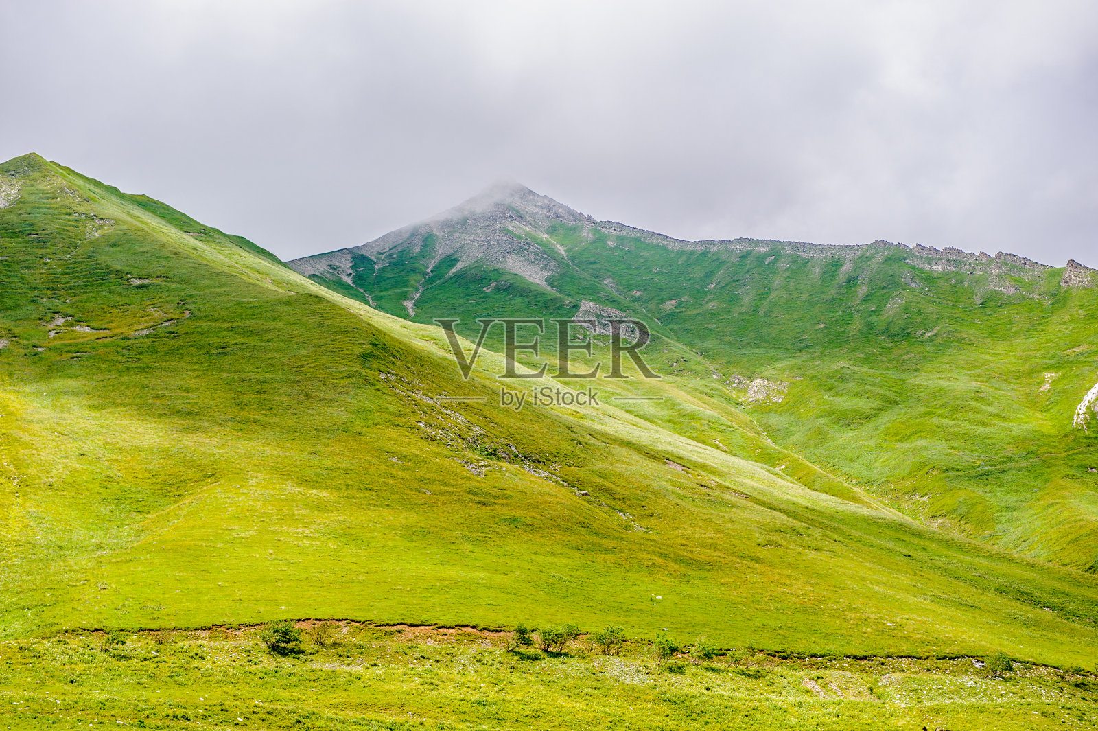 岩石在草和大自然的美丽的绿色山脉照片摄影图片