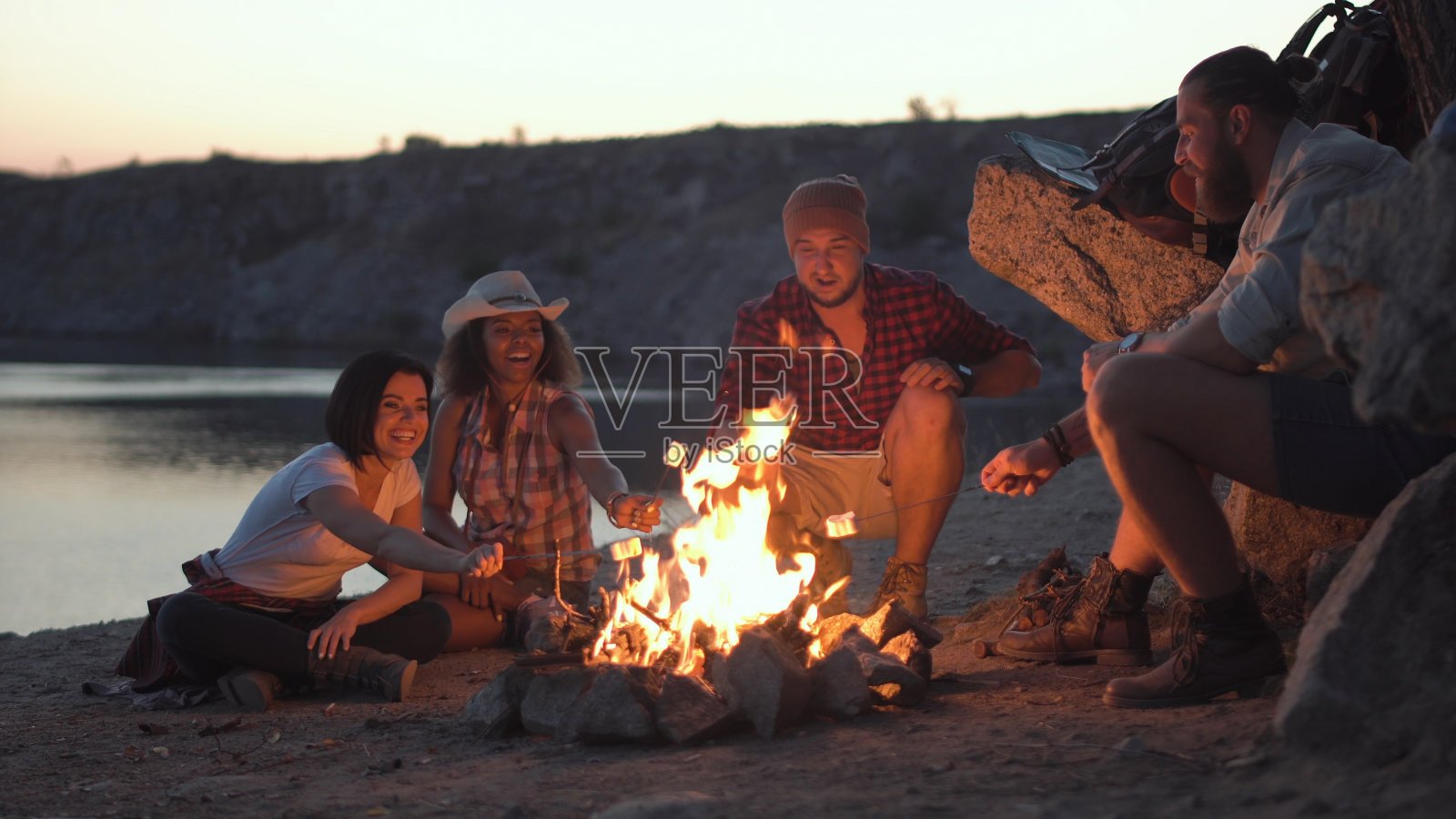 欢乐的朋友们在篝火旁放松照片摄影图片