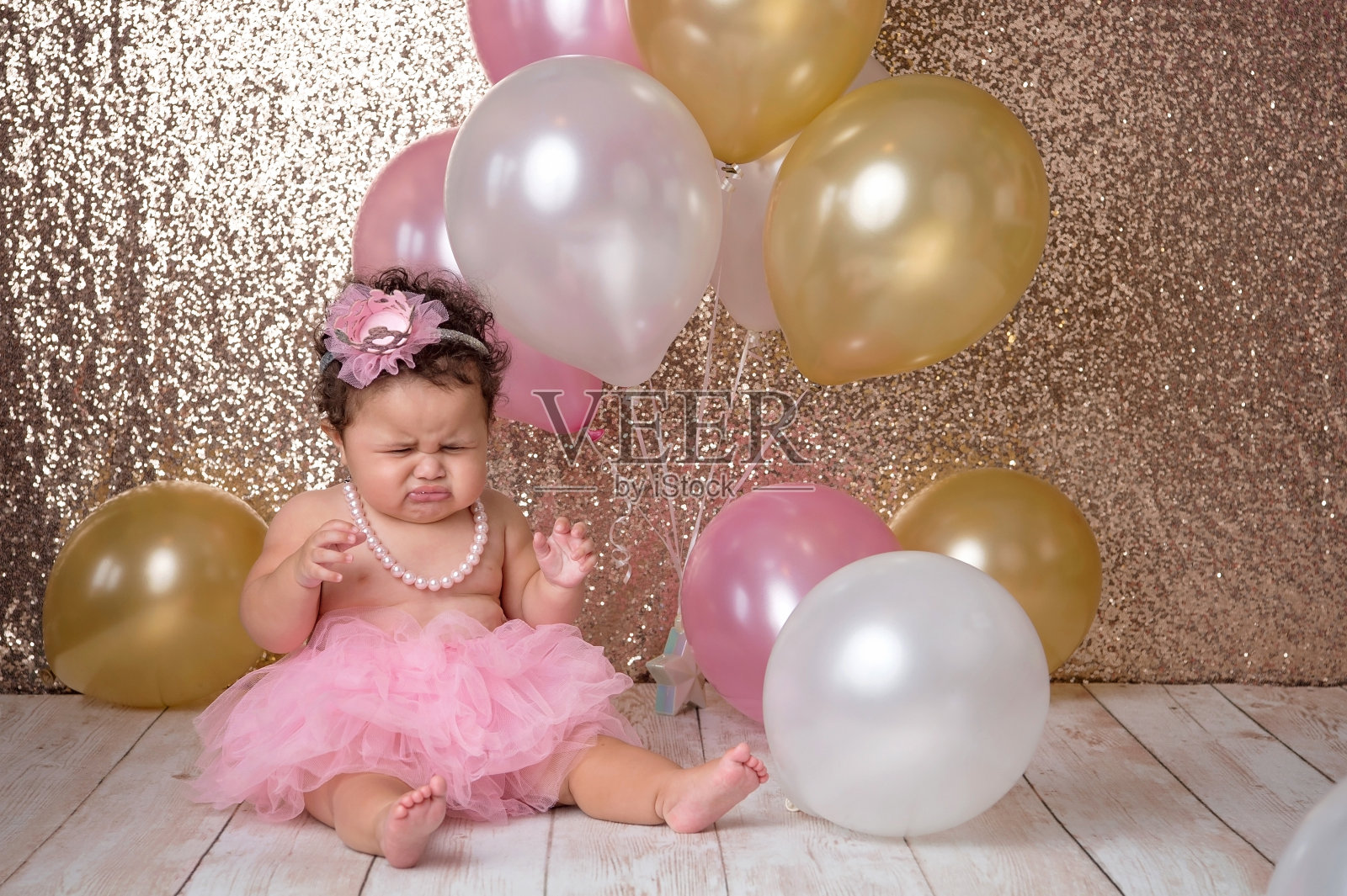 一岁的小女孩拿着气球哭照片摄影图片