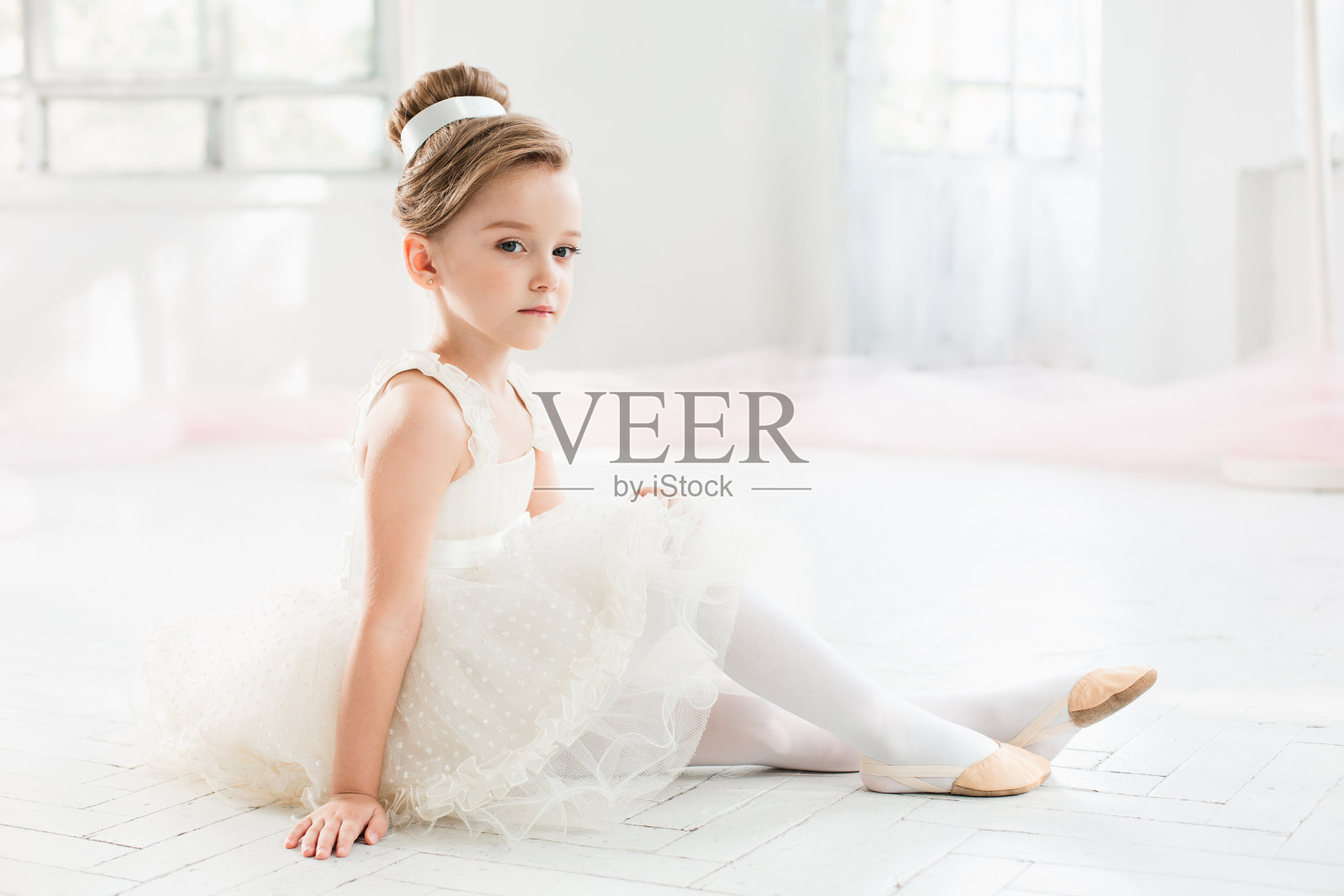 在芭蕾舞学校的课堂上穿着白色芭蕾舞裙的小芭蕾舞女照片摄影图片