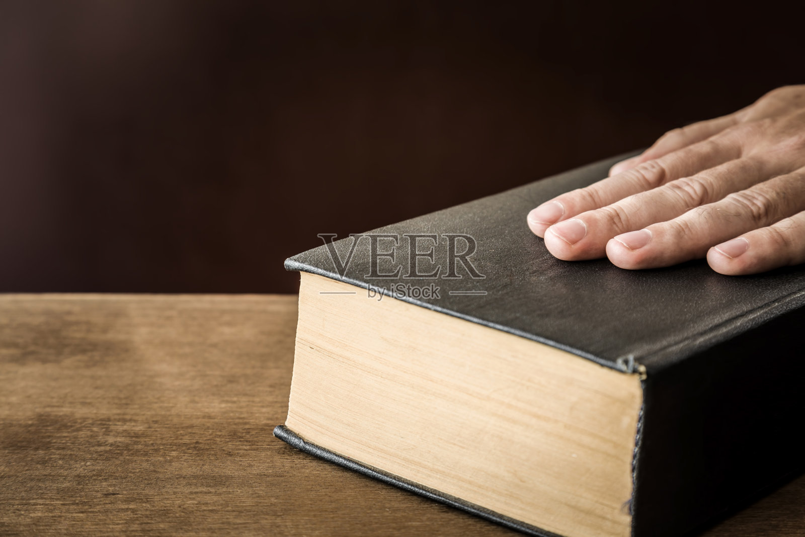 男人的手对着圣经发誓。一个宣誓就职。照片摄影图片
