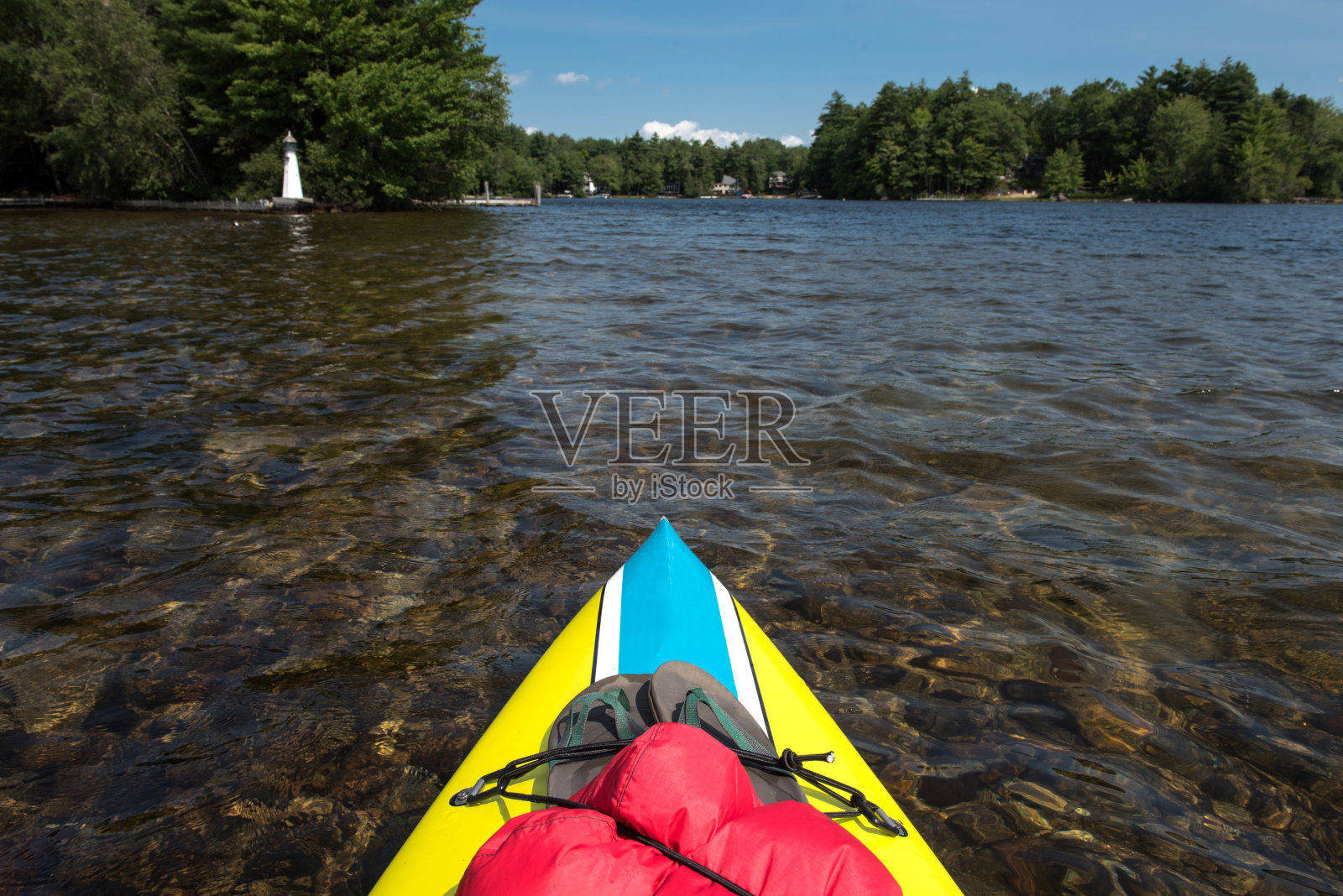 从船头的观点立式桨板干袋和拖鞋在缅因州的一个湖。照片摄影图片