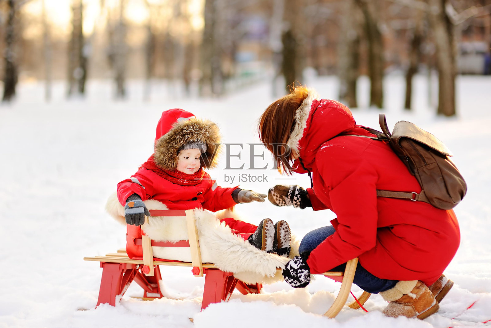 漂亮的蹒跚学步的男孩和他的母亲在冬天玩得开心照片摄影图片