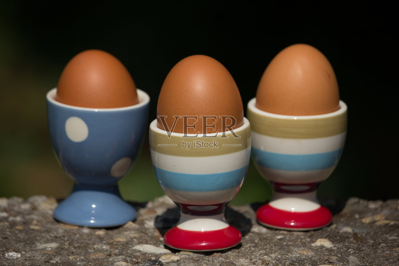 三个鸡蛋和杯子与黑暗模糊的背景照片摄影图片