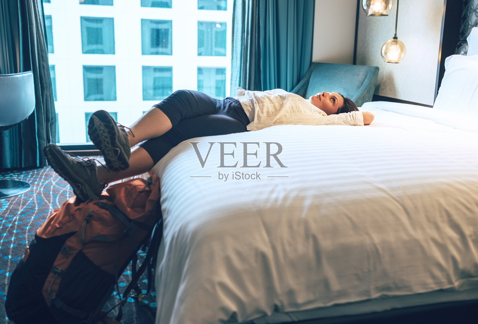 女游客背包客放松在高质量的酒店房间照片摄影图片
