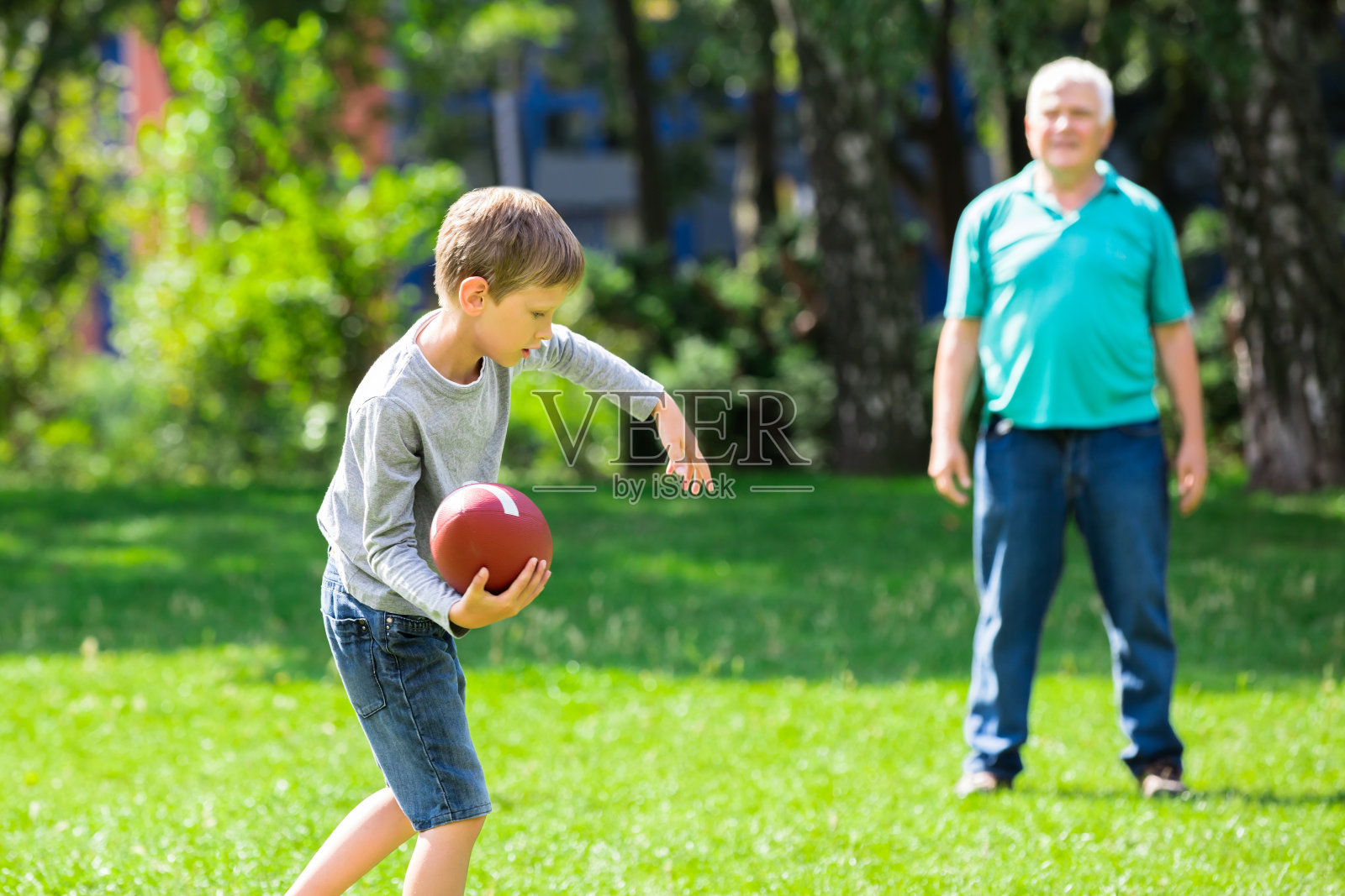 孙子和爷爷在玩橄榄球照片摄影图片