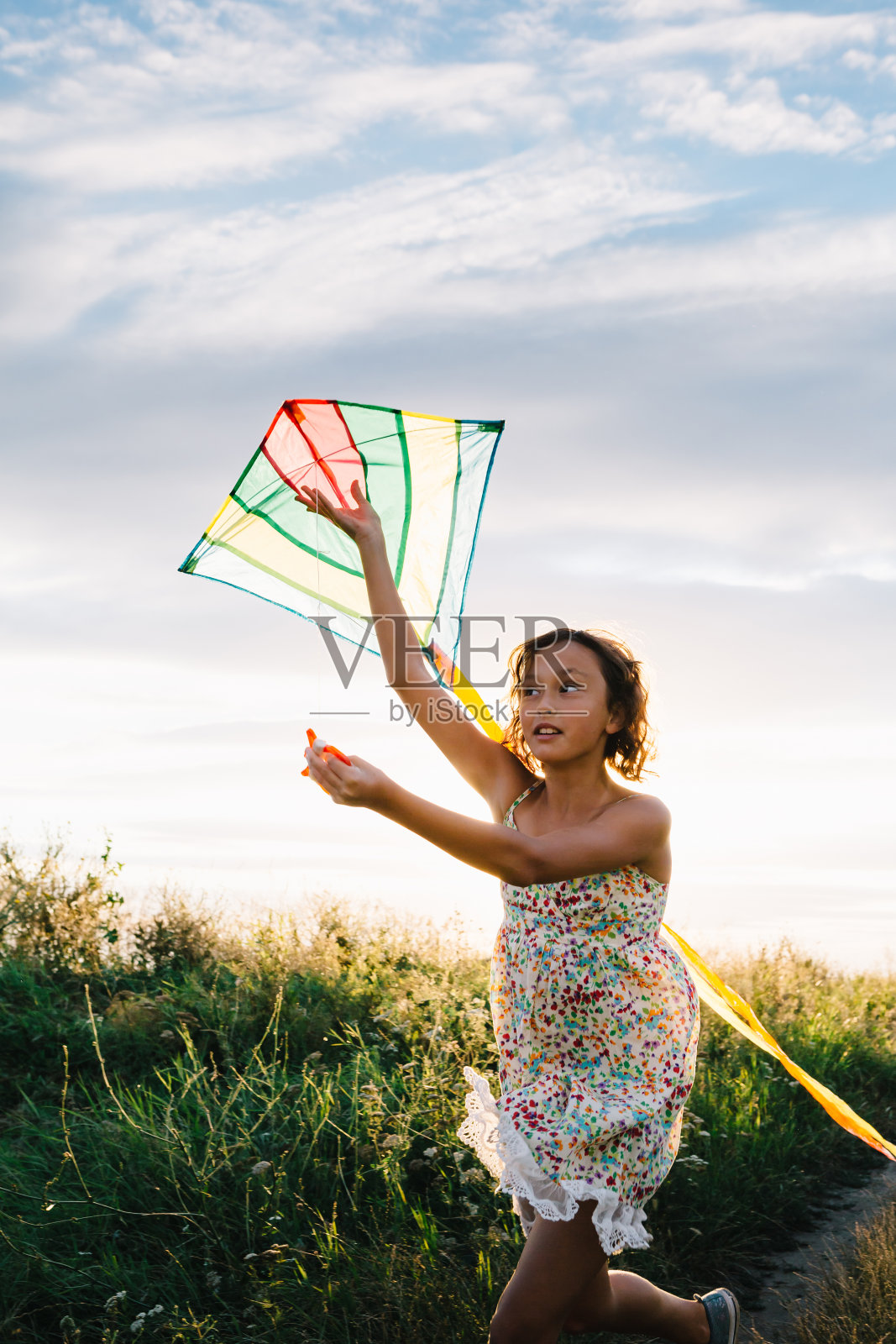 女孩拿着风筝在田野里奔跑照片摄影图片
