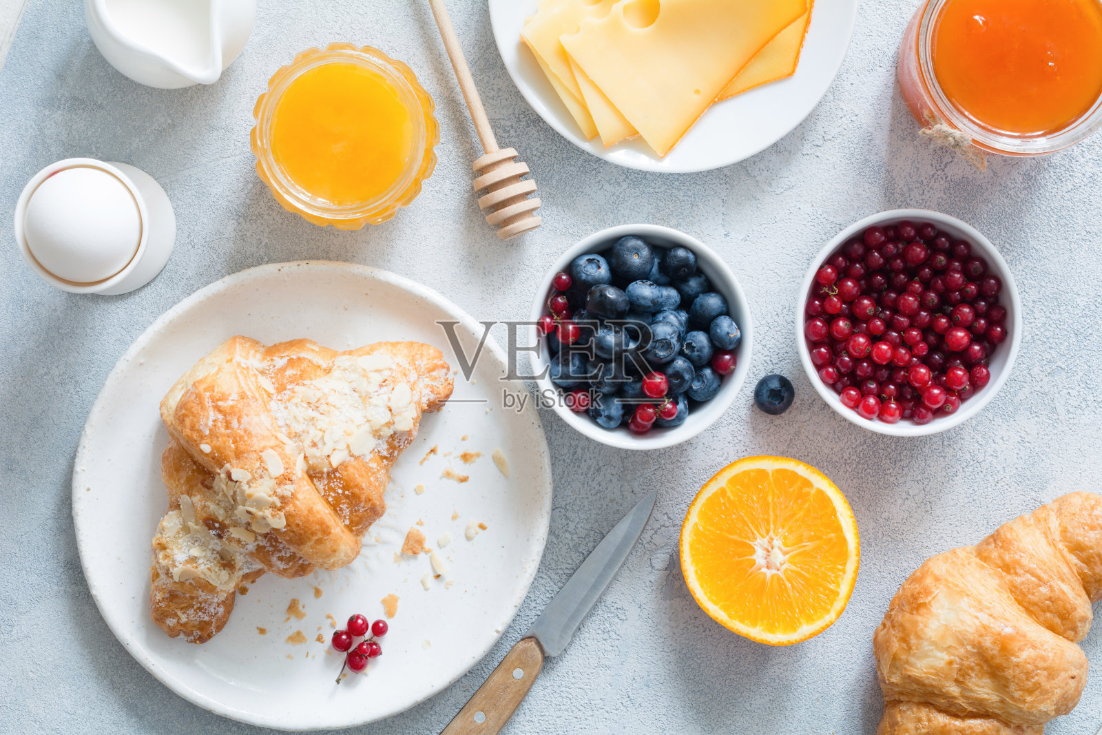 羊角面包，蜂蜜，奶酪，果酱，新鲜浆果和水果。大陆式早餐照片摄影图片