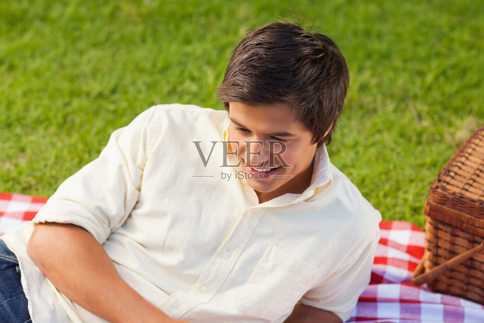 男人微笑着躺在野餐毯子上照片摄影图片