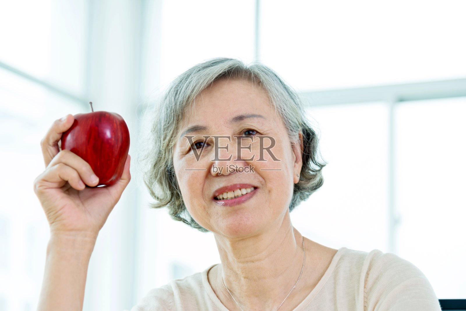 家里拿着苹果的老妇人照片摄影图片