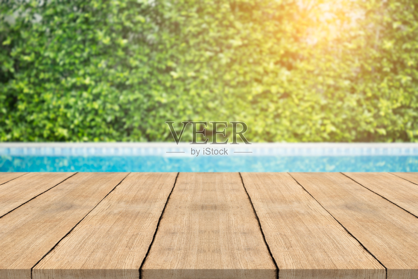 前面空荡荡的木桌，游泳池的模糊背景照片摄影图片