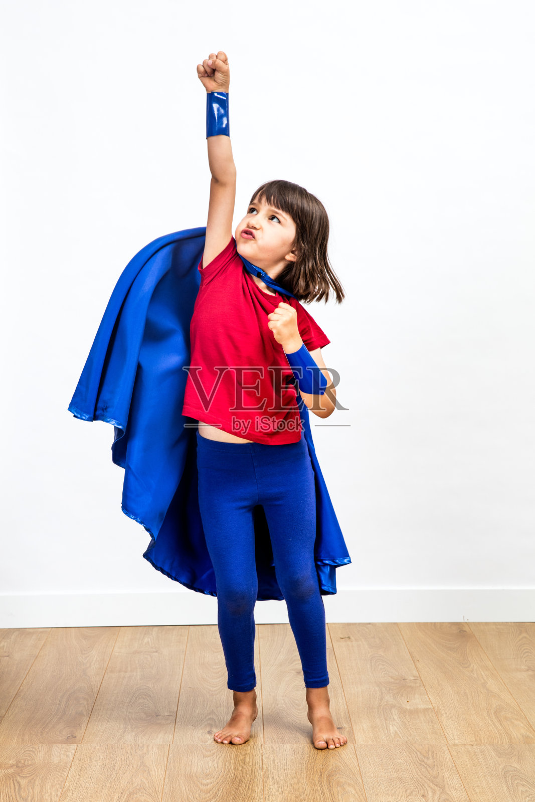 有动力的超级英雄孩子，表现出力量和想象力，达到成功照片摄影图片