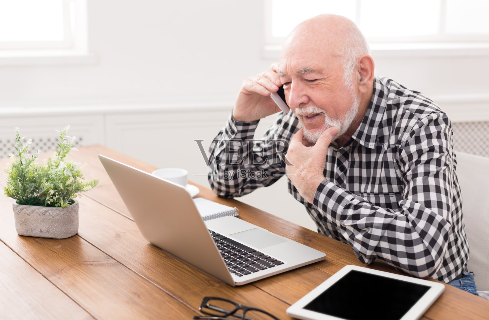 一个老男人用笔记本电脑打电话照片摄影图片