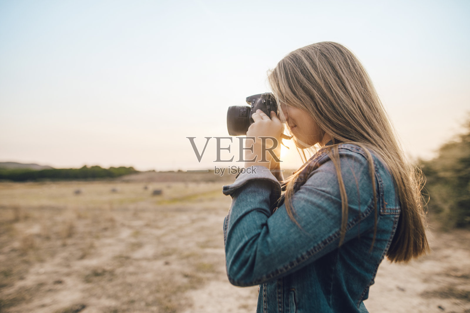 年轻女子使用单反相机照片摄影图片