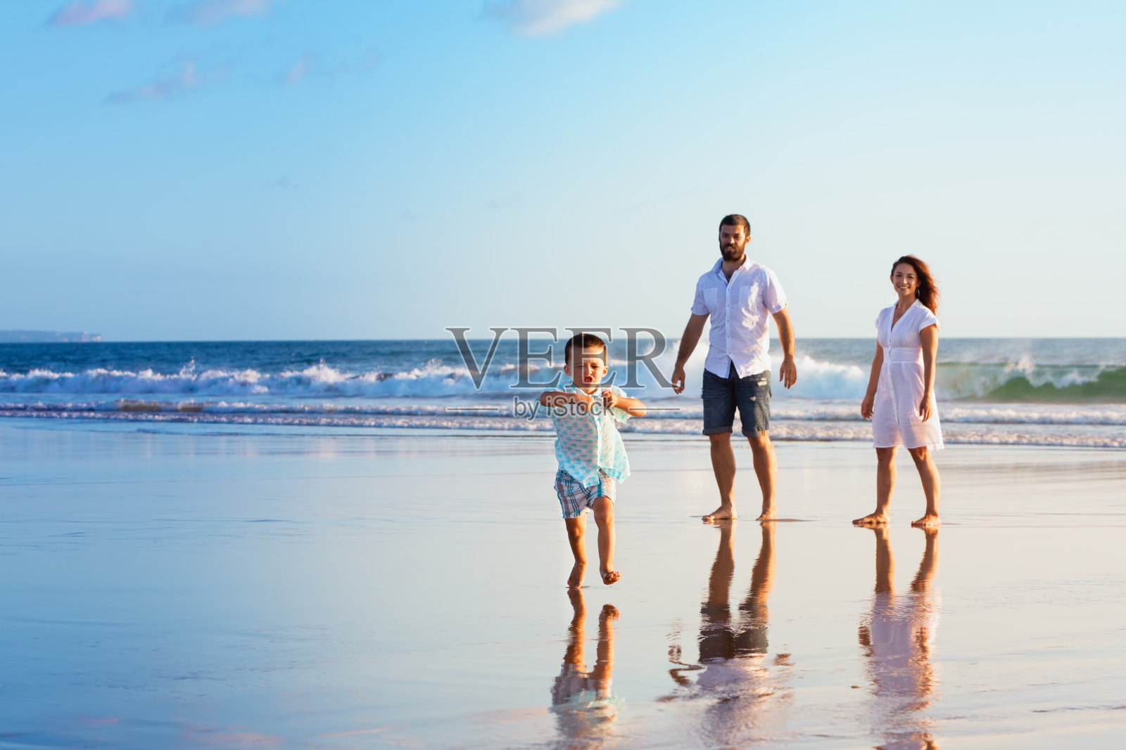 幸福的家庭在日落海滩上玩照片摄影图片