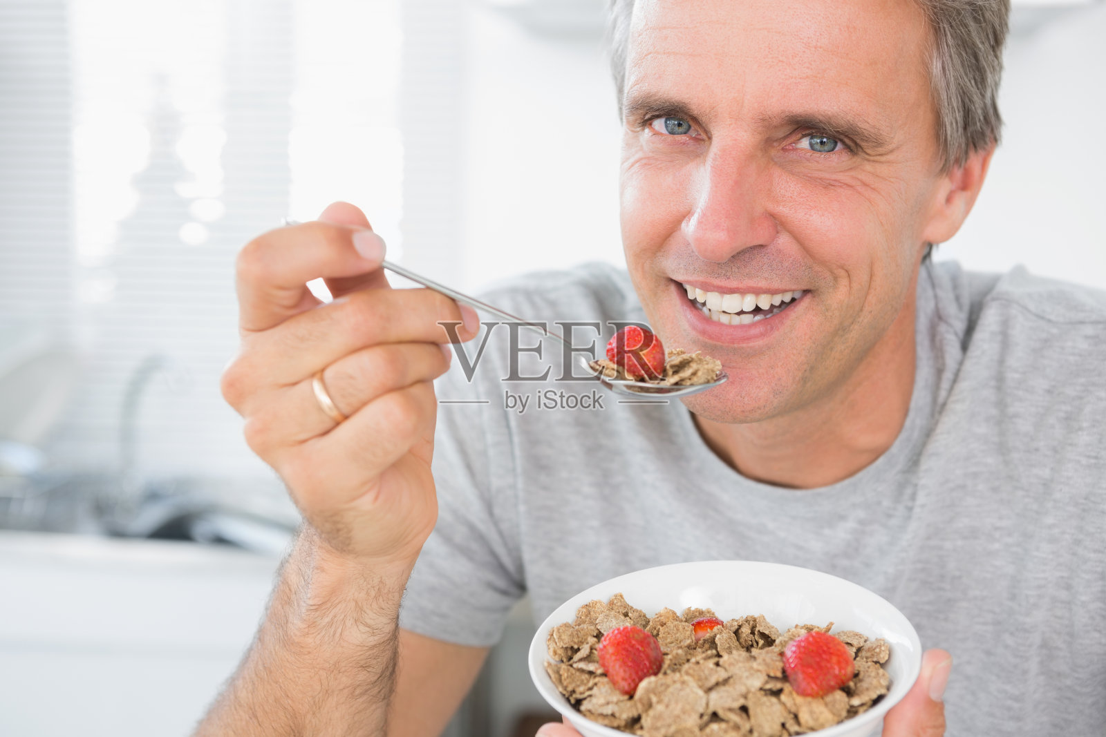 早餐吃麦片的快乐男人照片摄影图片