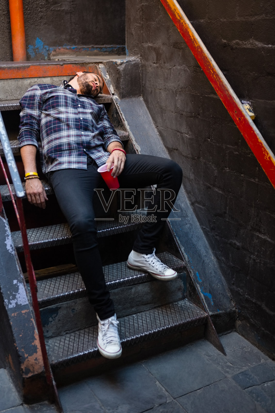 一个醉汉躺在楼梯上照片摄影图片