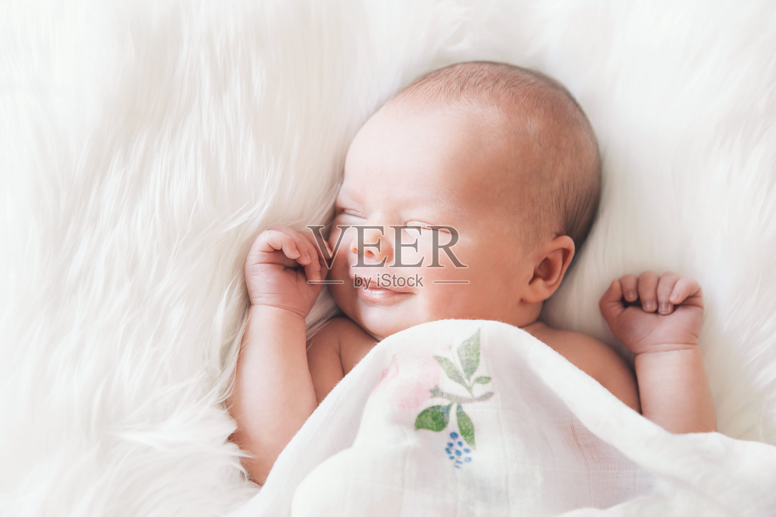 睡在白色毯子里的新生婴儿。照片摄影图片