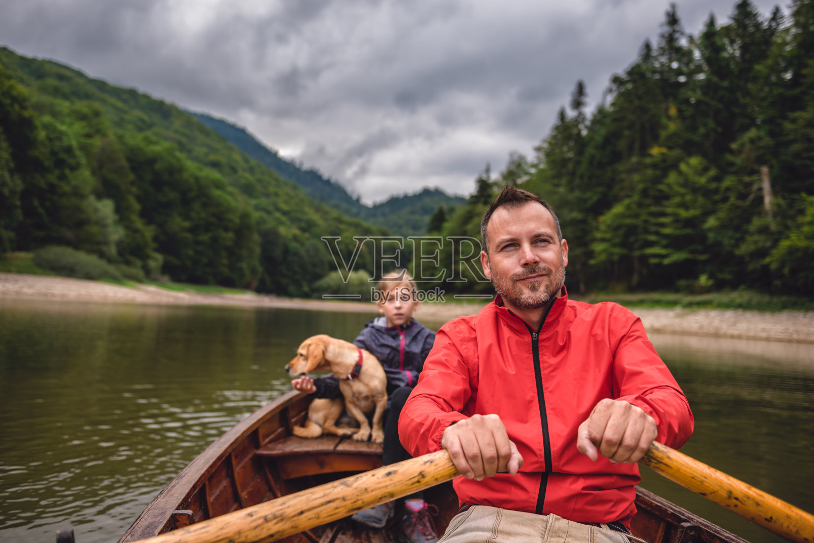 父亲和女儿带着一只狗划船照片摄影图片