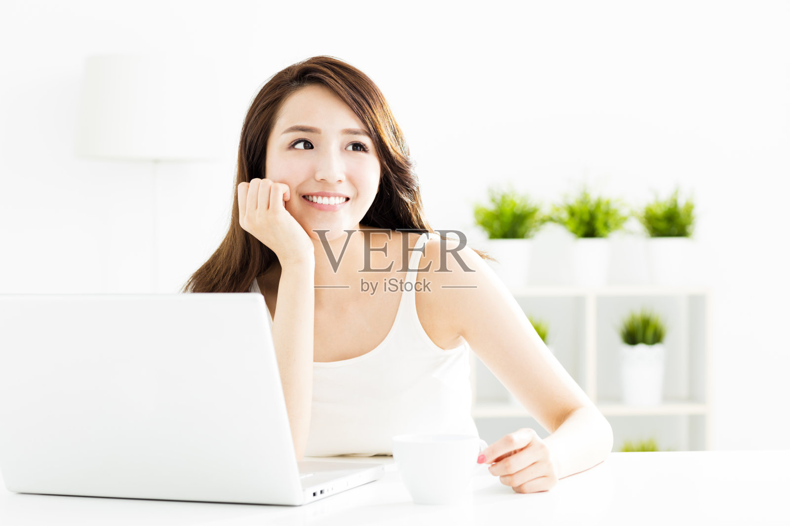 微笑的年轻女子，手提电脑在客厅照片摄影图片