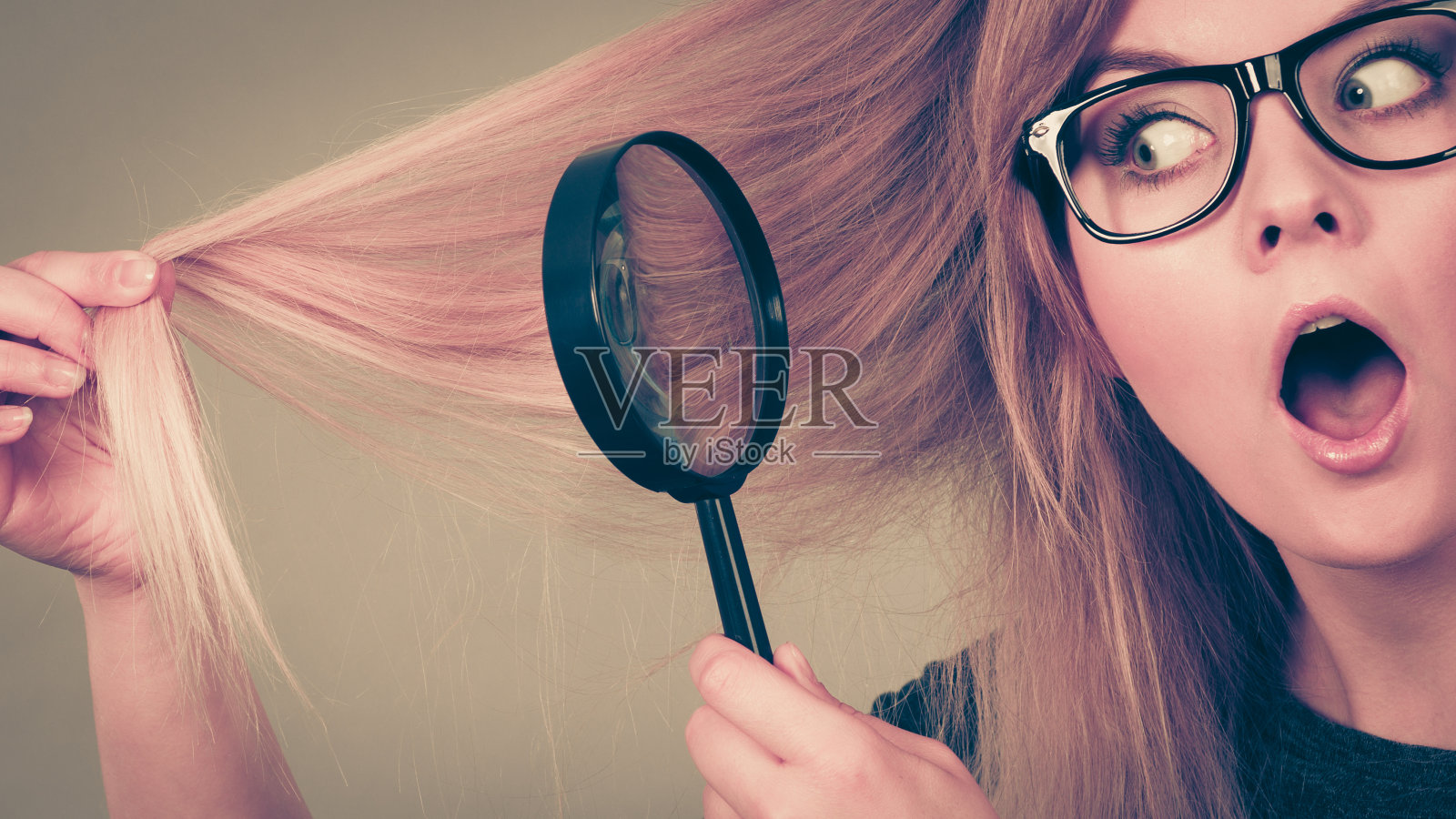 拿着放大镜看头发的女人照片摄影图片