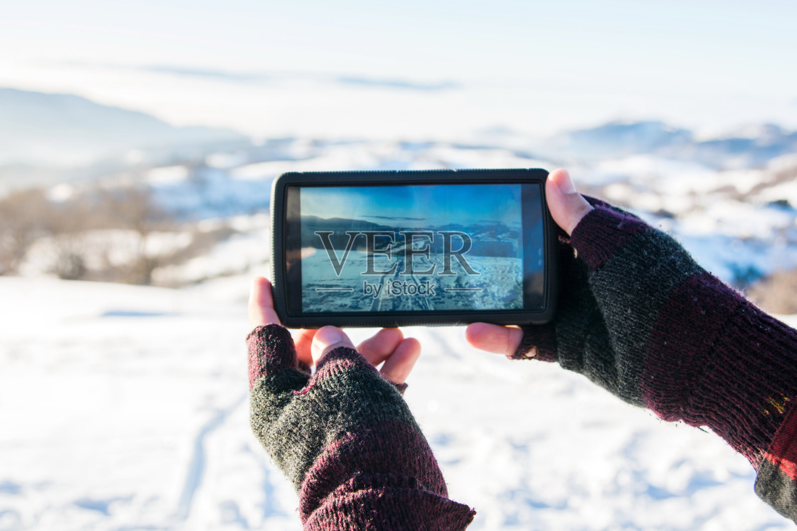 男人在冬天用智能手机拍照照片摄影图片