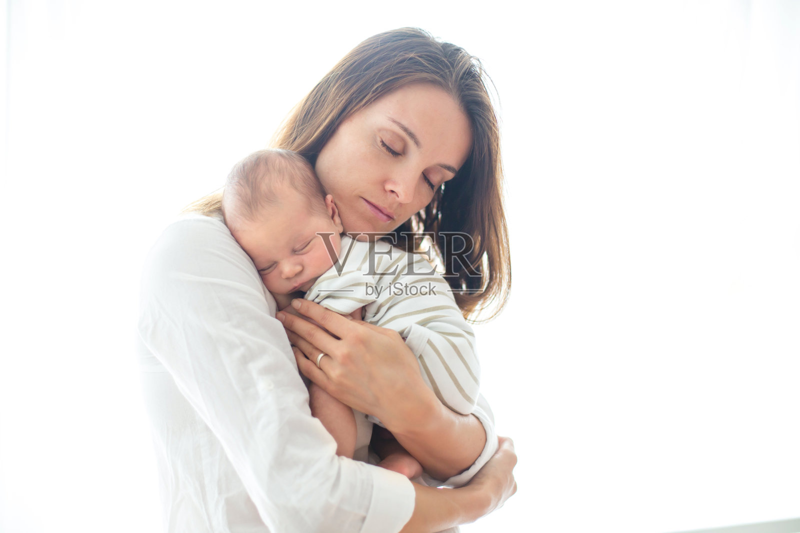 年轻的母亲，抱着她刚出生的儿子照片摄影图片