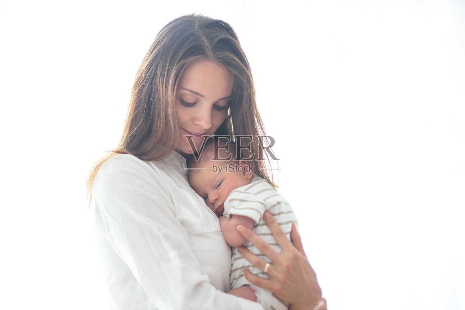 年轻的母亲，抱着她刚出生的儿子照片摄影图片