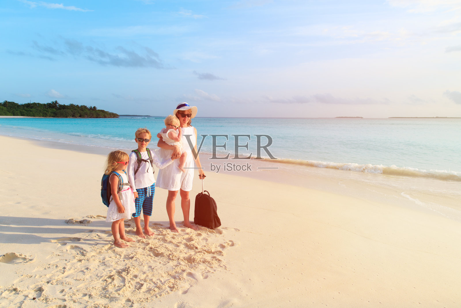 一家人带着孩子去热带海滩旅游照片摄影图片