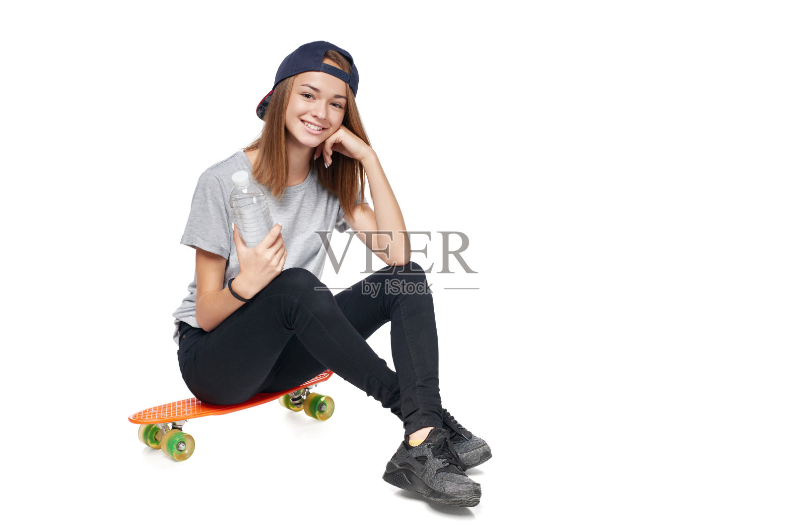 少女全身坐在滑板上照片摄影图片
