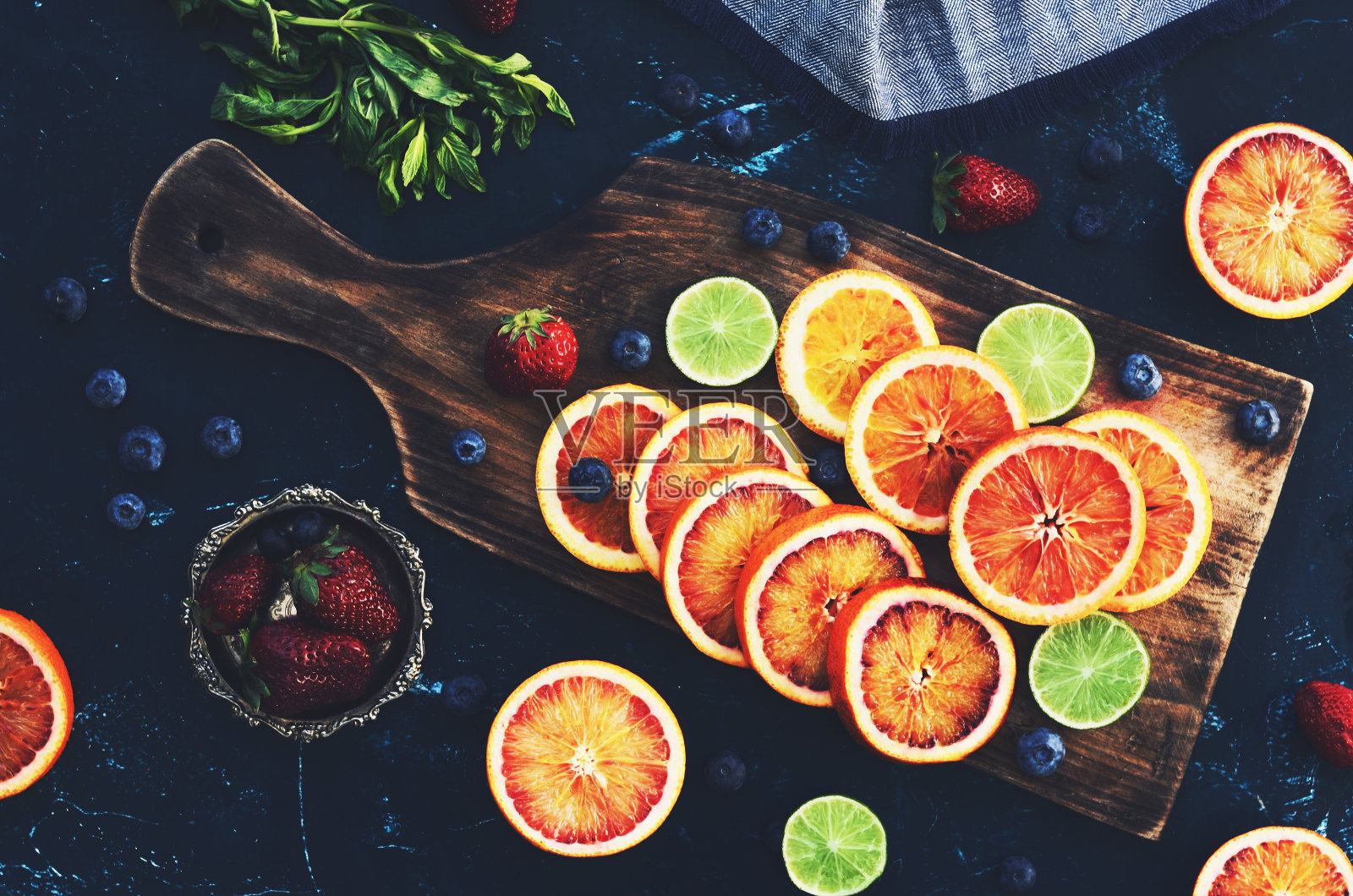 混合各种柑橘类水果-红橙和酸橙在木砧板上照片摄影图片