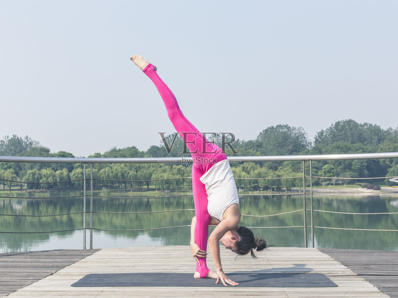 在木桥上练习瑜伽的女人照片摄影图片