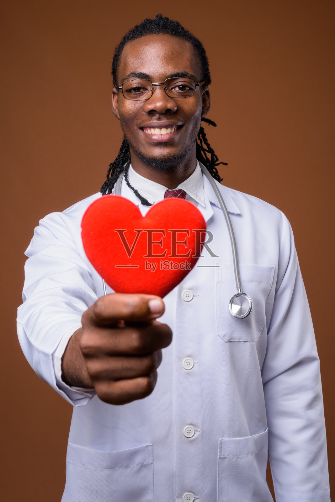 工作室拍摄的年轻英俊的非洲男子医生戴眼镜，以有色的背景照片摄影图片