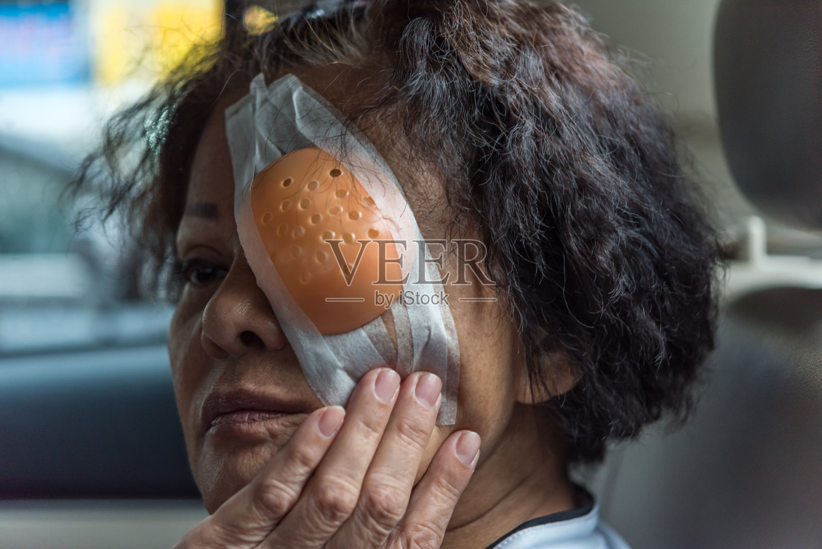 患者亚洲老年妇女60多岁与黑头发和脸上皱纹显示她的眼睛与眼垫和眼罩后角膜手术(lasik)由眼科医生在医院，美容保健概念照片摄影图片