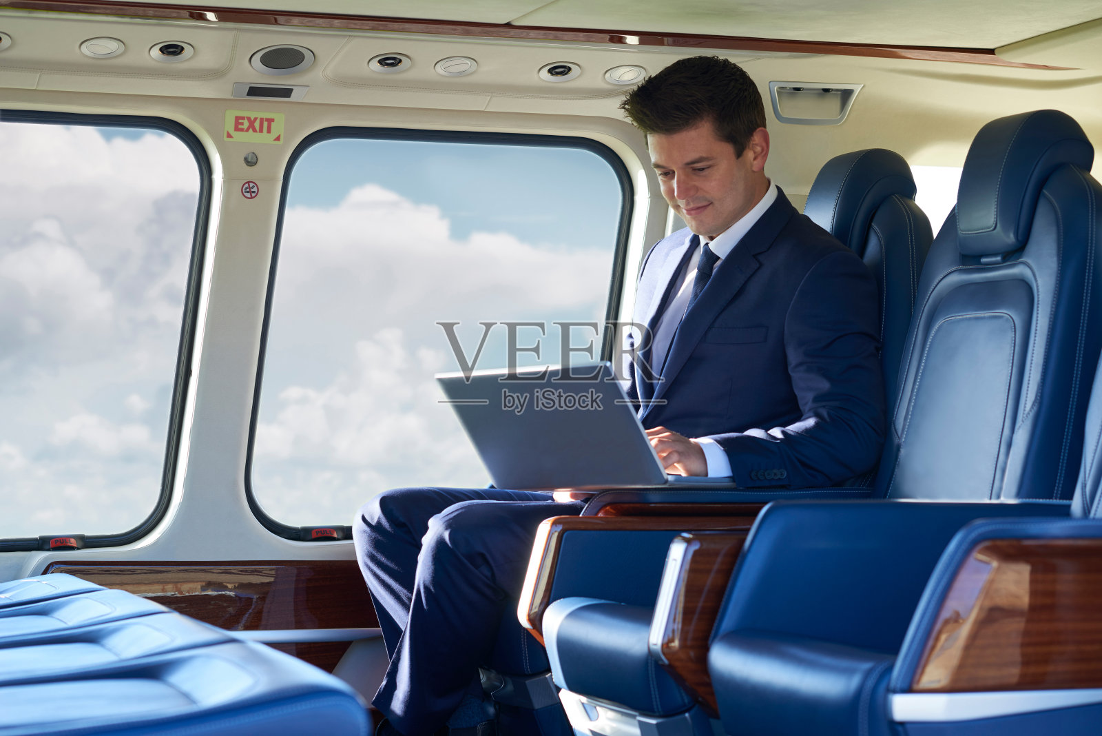 飞行员在直升机机舱里用笔记本电脑工作照片摄影图片