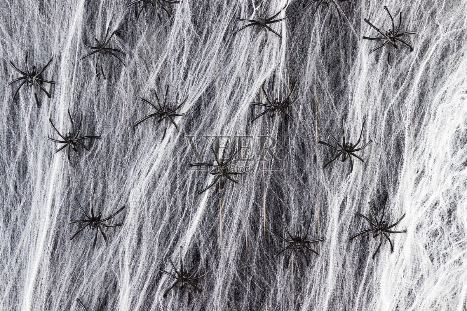密密麻麻的蛛网上有黑色的蜘蛛作为万圣节的背景。照片摄影图片