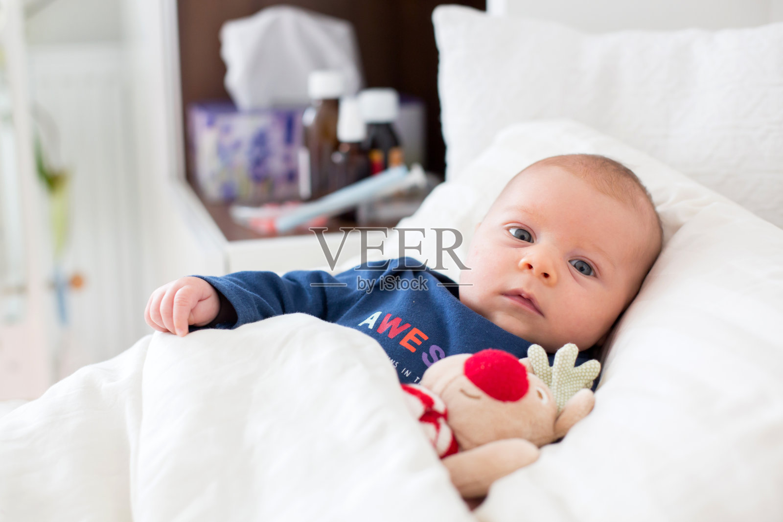 可爱的新生男婴，躺在床上受寒照片摄影图片