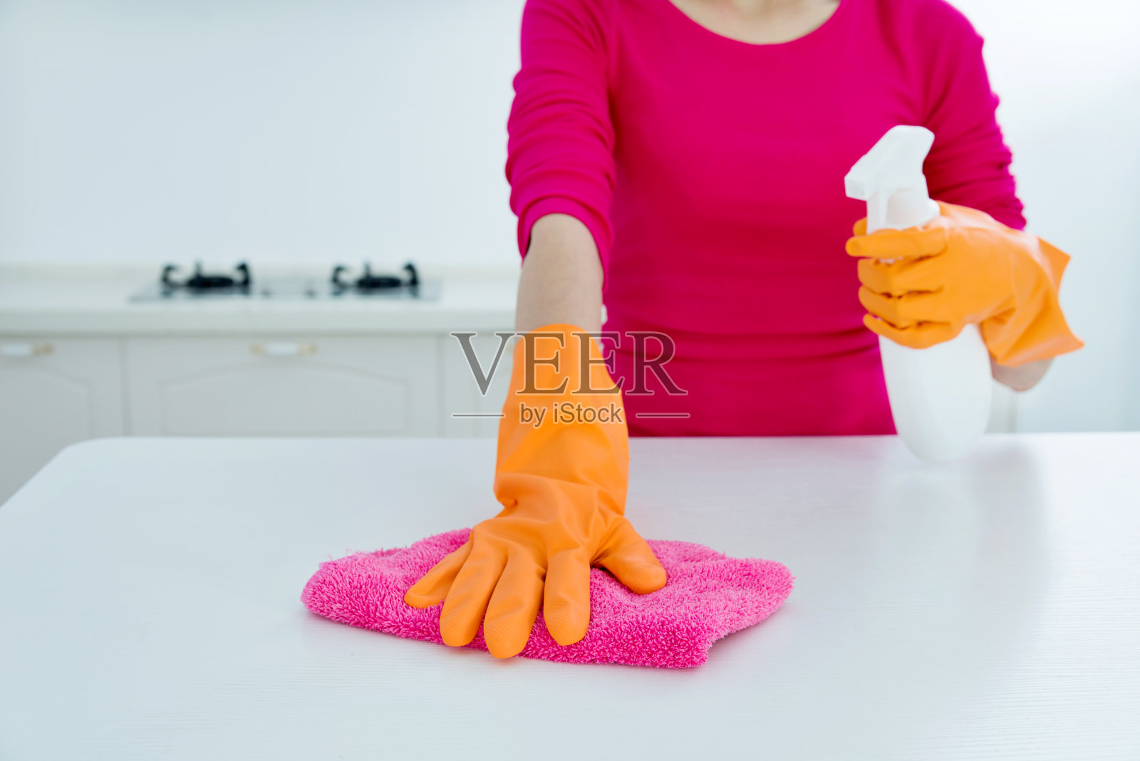 一个女人在用喷雾器清洁厨房柜台照片摄影图片