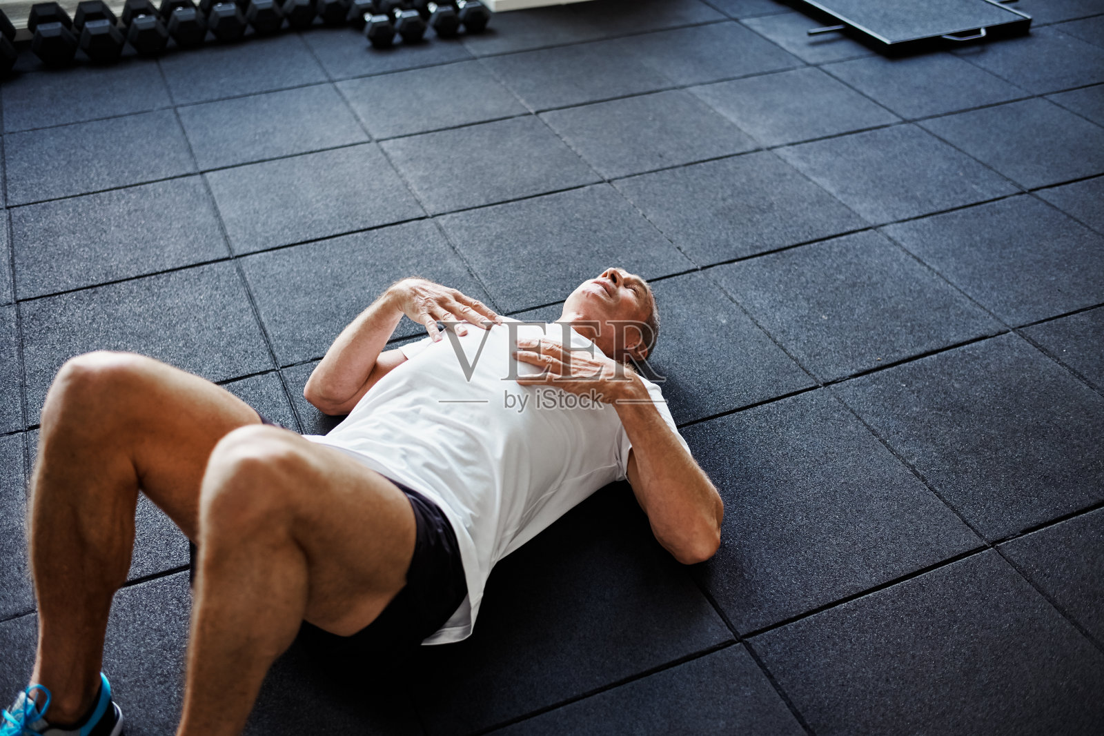 精疲力竭的男人在健身后躺在健身房的地板上照片摄影图片