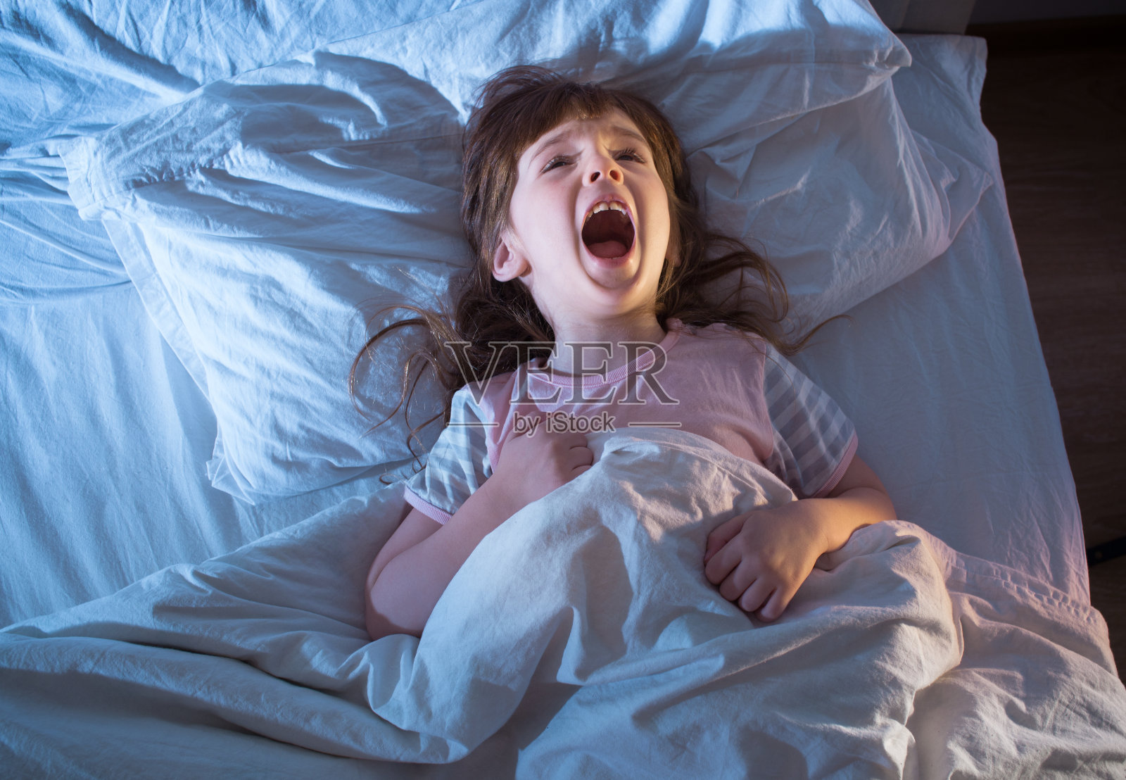 4岁女孩躺在床上尖叫照片摄影图片