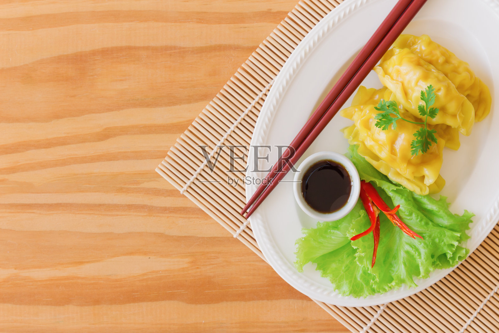 自制的肉馅或虾饺和蘸酱油的木桌在俯视图平铺与复制空间。美味的饺子或点心供早餐或晚餐。点心是中国食物。照片摄影图片