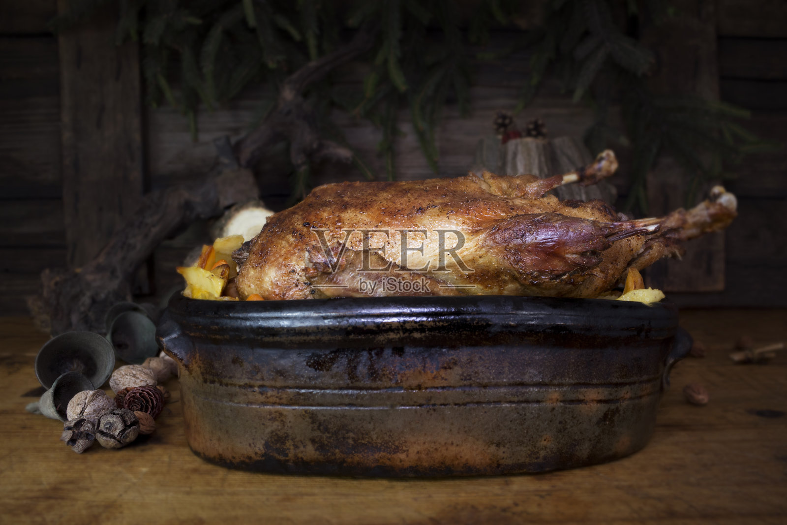 圣诞烤鸭在木头和松枝的木头桌子的背景照片摄影图片