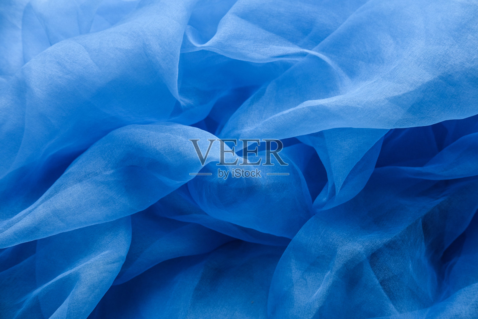 织物蓝色波浪-材料的背景和纹理。照片摄影图片