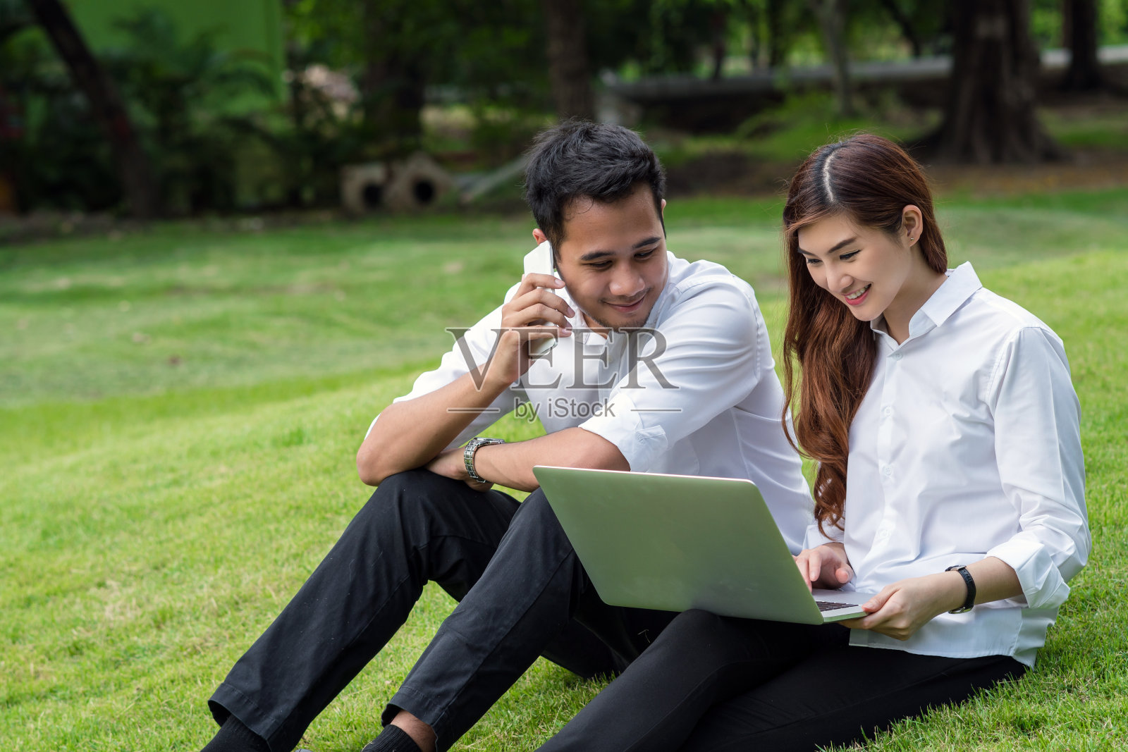 快乐的亚洲夫妇大学工作通过科技笔记本电脑在公园，商业和生活方式的概念照片摄影图片